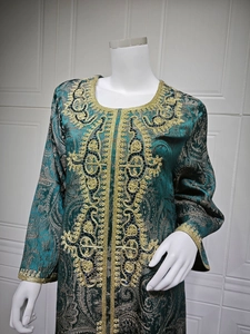 Close-up of gold embroidery and beadwork on dark green jacquard kaftan evening dress