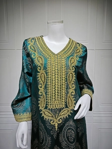 Détails de broderie dorée sur caftan jacquard vert foncé aux motifs paisley
