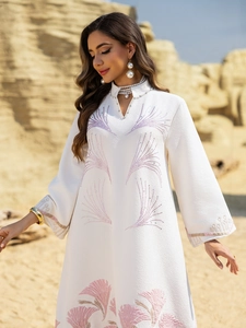 Close-up of white jacquard dress with pink embroidery and pearl neckline detail