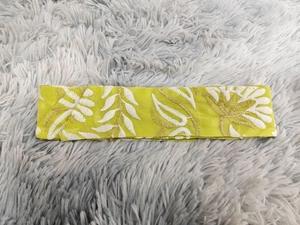 Dettaglio della fascia giallo-verde con ricamo a foglia dorata su fondo di pelliccia