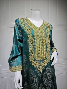 Détails de broderie dorée sur une robe caftan vert foncé avec un décolleté en V profond
