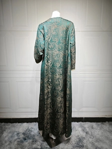 Detail of dark green Kaftan with gold Paisley jacquard pattern on high-quality fabric