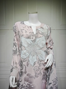 Detail of pink embroidered dress with floral prints, white beadwork and shiny sequins