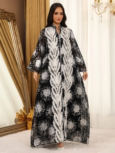 Detail einer eleganten schwarzen Abaya aus Netzstoff mit weißen Sonnenblumen-Stickereien