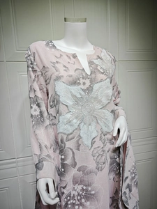 Detailed view of hand-beaded silver sequins and 3D floral accents on pink dress