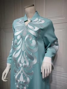 Detail of silver embroidery on teal ethnic dress with traditional mandarin collar