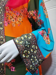 Detail of colorful floral print dress with intricate rhinestone embellishments on sleeves