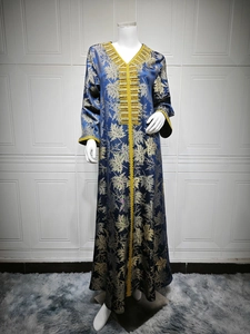 Detail of heavy gold embroidery and beadwork on a navy blue long sleeve dress