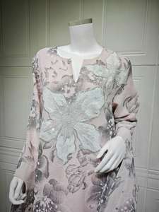 Close-up of pink long sleeve top with floral prints, white beads and sequin floral detail