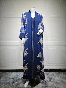 Close-up of golden palm leaf embroidery on a dark blue chiffon open abaya cardigan