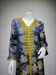Macro shot of V-neckline featuring heavy golden beadwork and embroidery on navy dress