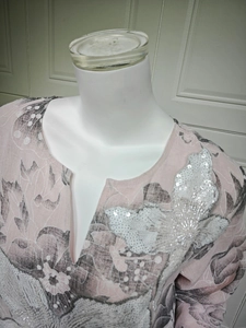 Detailed V-neck of a pink floral dress with shimmering butterfly sequin embroidery