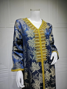Detailed view of navy blue dress featuring gold maple leaf prints and bead embroidery