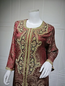 Detailed gold thread embroidery and black beadwork on the neckline of a wine red kaftan