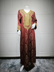 Détails de broderies dorées et motifs jacquard sur la robe longue Kaftan rouge bordeaux
