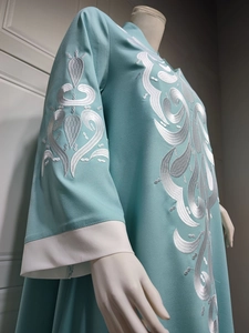Detailed close-up of intricate white embroidery on teal ethnic maxi dress sleeves