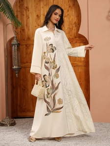Detail of sequin floral embroidery and jacquard texture on off-white long sleeve dress