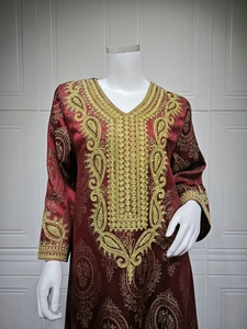 Détail de la robe caftan bordeaux avec broderie paisley dorée et texture jacquard de luxe