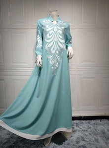 Detail of silver embroidery on light blue traditional dress with white contrast borders