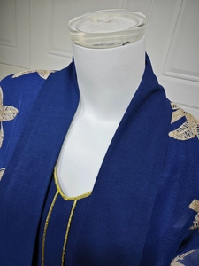 Detail of navy embroidered maxi dress with gold floral stitching and V-neckline border