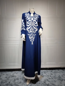 Detail of silver floral embroidery on a dark blue ethnic maxi dress with V-neckline