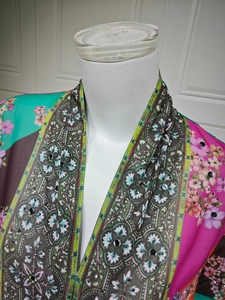 Detail of floral printed dress with intricate sequins and rhinestone neckline trim