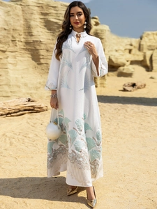 Detail of V-neck white kaftan dress with jacquard texture and pearl beaded accents