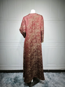 Detailed view of dark red evening kaftan dress with golden paisley jacquard patterns