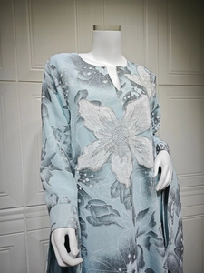 Detail of light blue embroidered dress with white sequins, beads and floral appliques