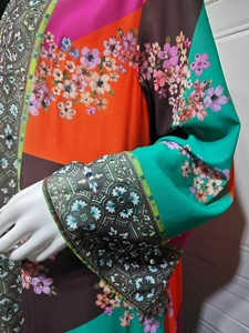 Detail of bohemian print maxi dress with intricate hand-applied rhinestones and floral patterns
