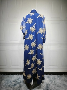 Detail of navy blue long dress showing golden palm tree embroidery and sheer mesh fabric