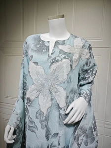 Detail of silver sequin flower embroidery on light blue floral pattern dress fabric