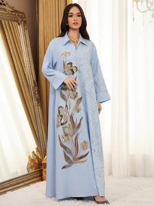 Close-up of light blue ethnic maxi dress featuring floral jacquard embroidery and sequins