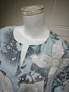 Detail of sequin embroidery and silver beadwork on floral v-neck tunic dress