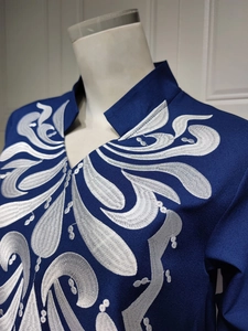 Detailed embroidery on a navy ethnic dress featuring traditional scroll patterns on the collar