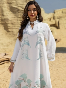 Detail of white maxi dress with pearl neckline and blue fan pattern embroidery