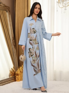 Detail view of light blue Abaya with colorful floral sequin embroidery and a pearl clutch