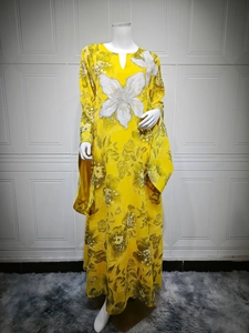 Detail of yellow floral dress showing intricate white sequin flower embroidery and beadwork
