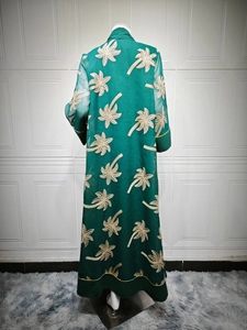 Detailed back view of emerald green abaya featuring intricate golden palm tree embroidery