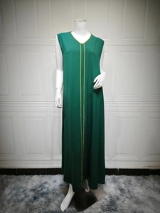Detail of dark green sleeveless dress featuring V-neckline and elegant gold trim on center