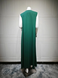 Back view of a sleeveless dark green maxi dress with flowing fabric on a mannequin
