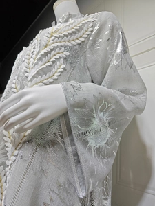 Detail der silbernen Blumenstickerei und weißen 3D-Spitzenapplikationen am langen Kleid