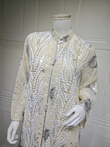 Detail von Stehkragen und silbernen Posamentenknöpfen am cremefarbenen Kleid