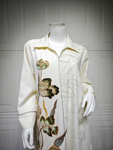 Detail showing floral sequin embroidery and leaf embossed texture on off-white long dress