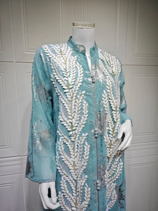Detail von hellblauer Netzstickerei und silbernen Metallic-Blattmustern auf dem Kaftan-Kleid