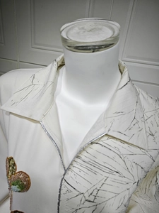 Macro shot of sequin butterfly embroidery and jacquard texture on white dress