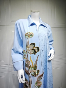Close-up of floral sequin embroidery and pleated texture on light blue maxi dress