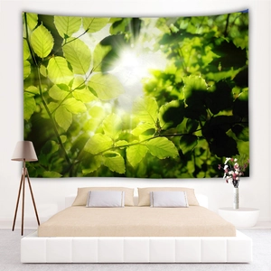 Detail of forest print tapestry showing green leaves and sunlight in a modern bedroom