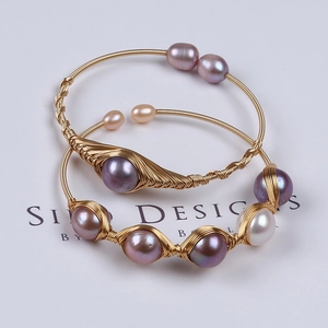 Detail of handmade 14K gold-filled wire wrapped bracelets with natural freshwater pearls