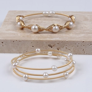 Handmade 14K gold filled natural freshwater pearl bracelets on beige stone background
